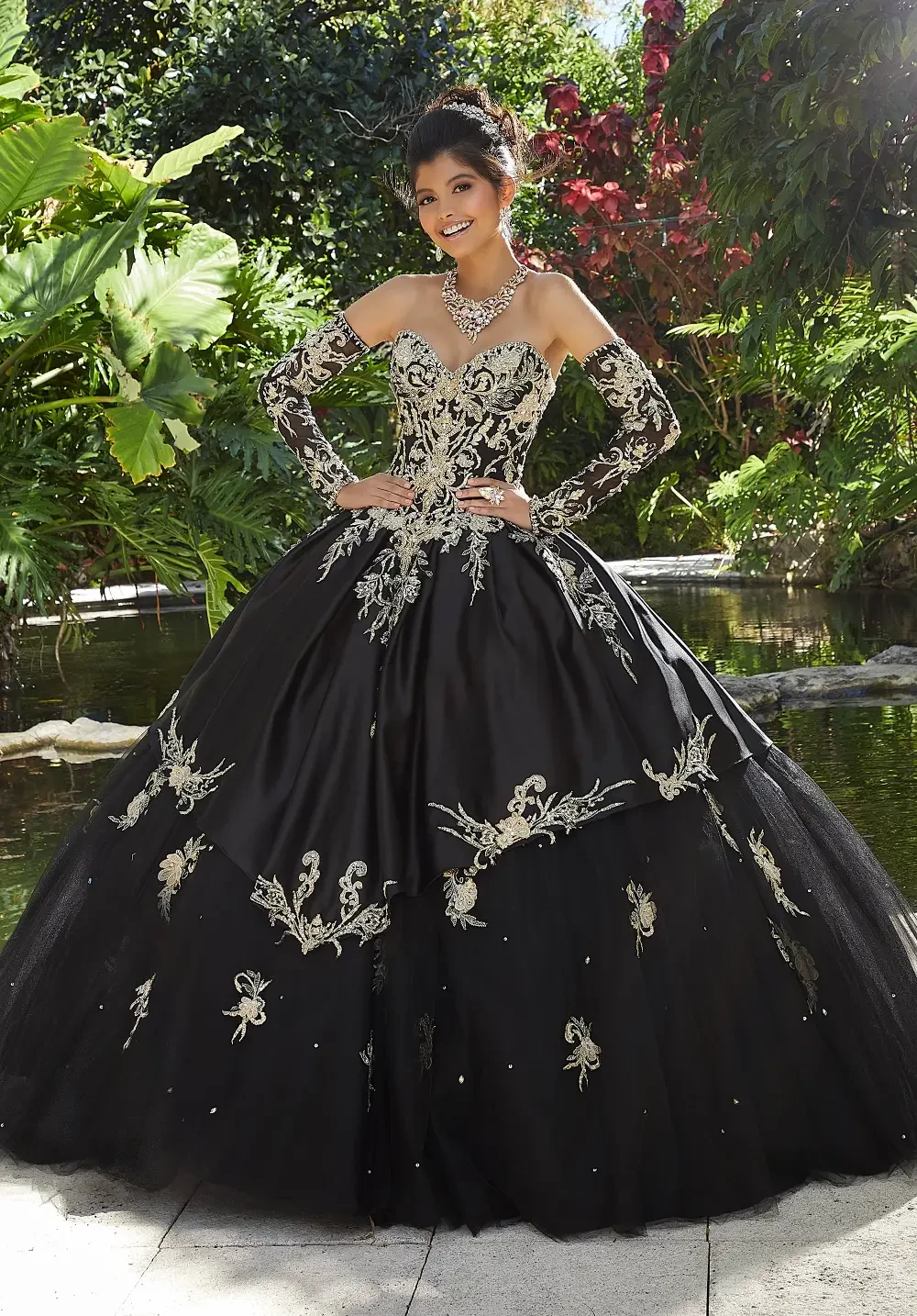 model is wearing a black and gold quince gown