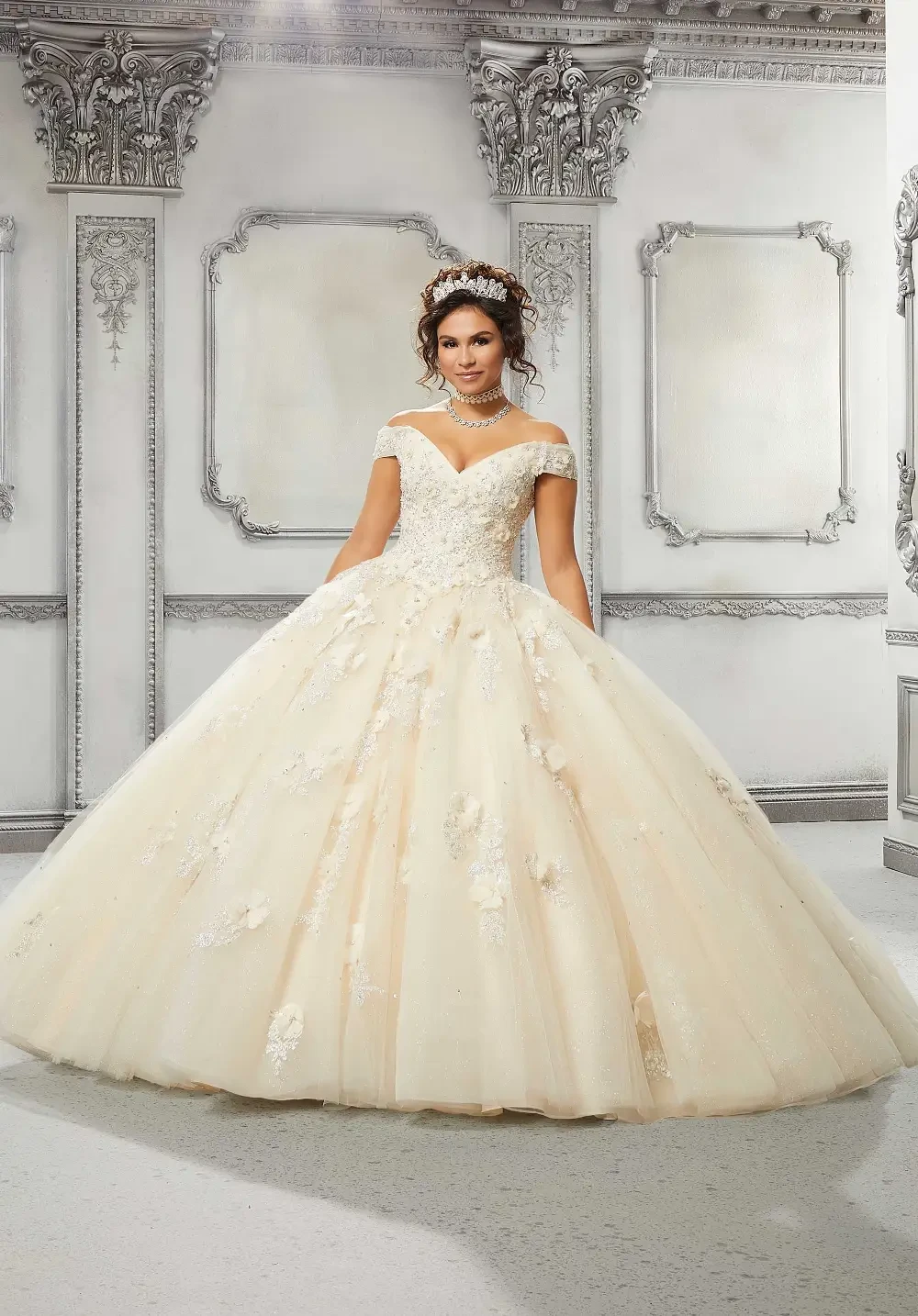 A bride in a beautiful ball gown wedding dress with a sweetheart neckline and floral embellishments, standing in an elegant, decorated environment.